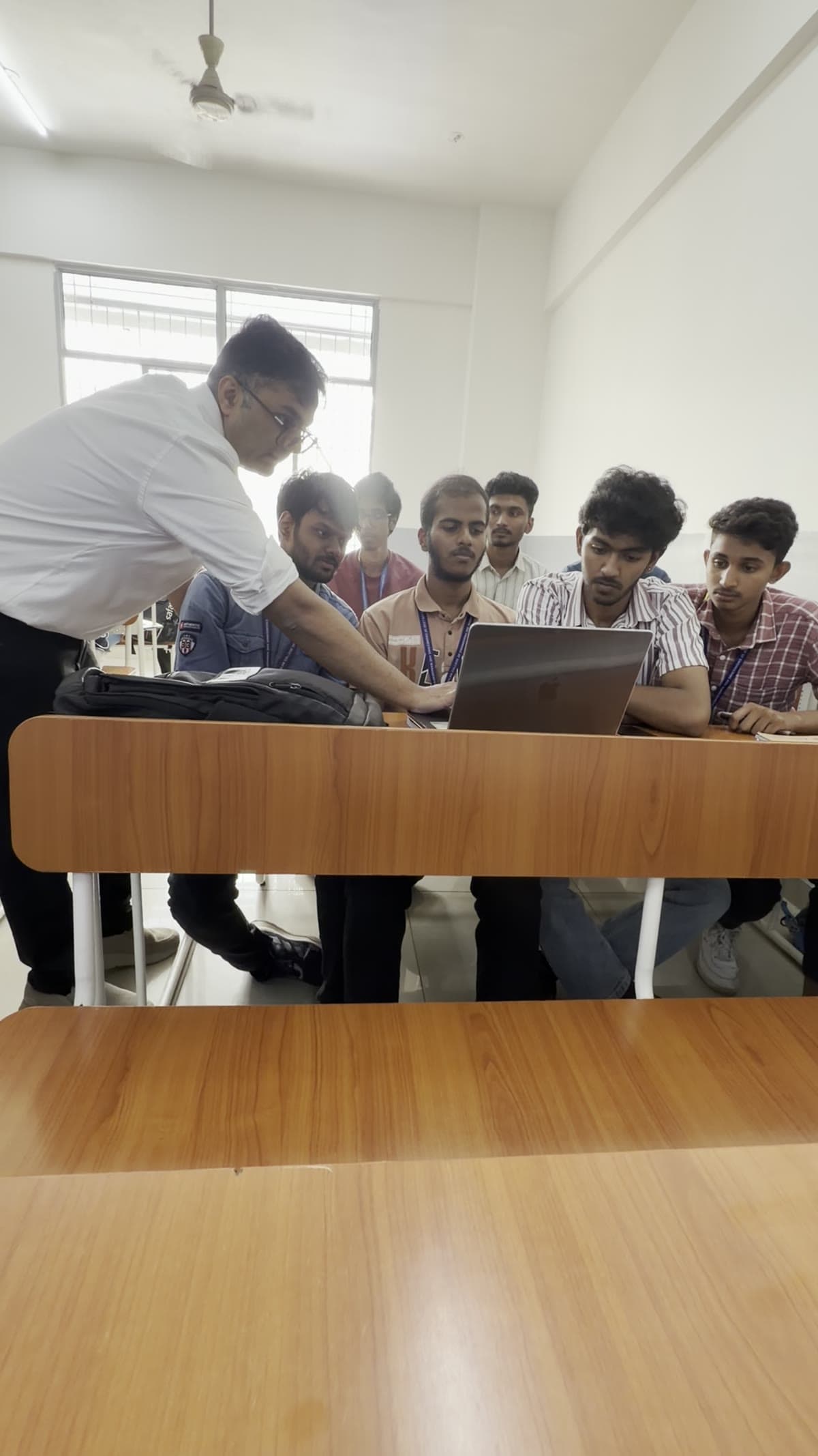 An instructor helping a small group of learners at their laptop